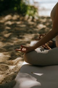Eine friedliche Szene mit einer meditativen Yoga-Praxis am Sandstrand.